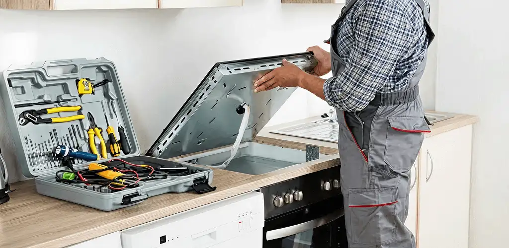 Handyman repairing a cooktop and checking wiring connections in Allentown, PA