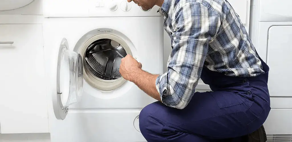 Handyman inspecting a dryer drum and internal parts for repair in Allentown, PA