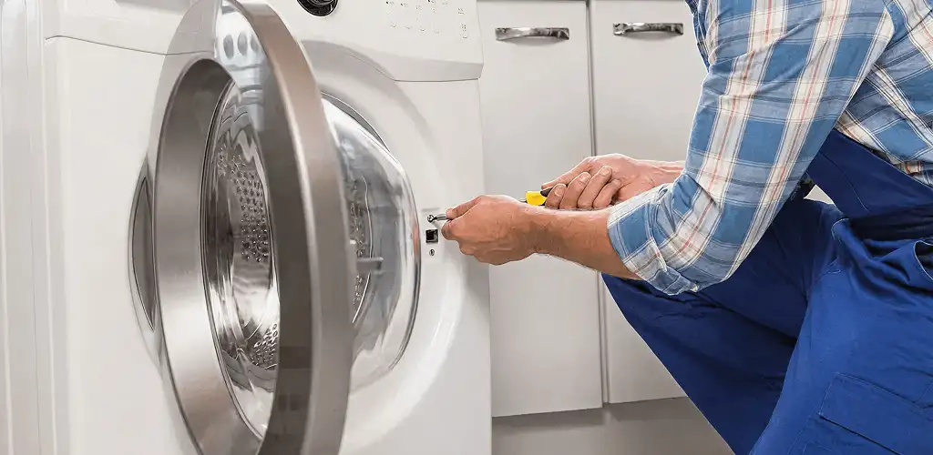 Handyman repairing a clothes dryer and checking electrical connections in Allentown, PA