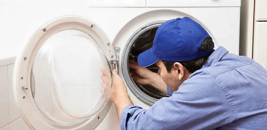 Washing machine repair handyman inspecting a front-load washer drum in Allentown, PA